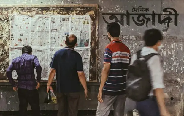 a group of people standing in front of a bulletin board
