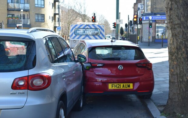 a red car is parked next to a silver car